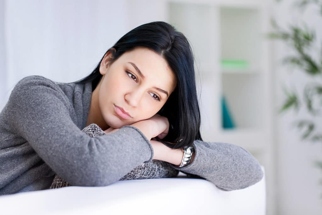 woman lays on her crossed arms while struggling with the effects of drug addiction