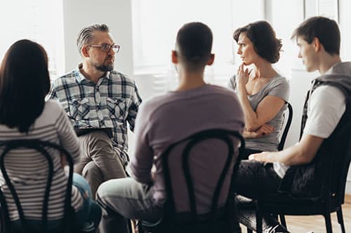 group of people sitting in a circle in alcohol rehab center program in Boston MA