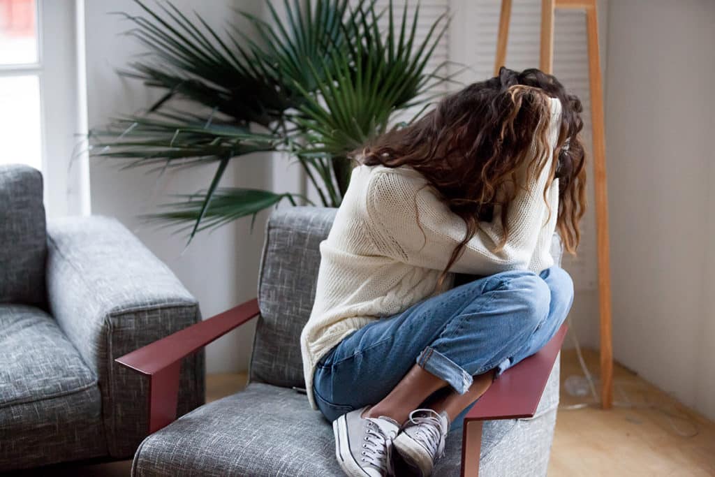 physical dependence, woman curled up on chair